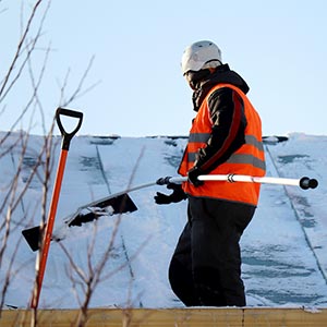 Roofer removing snow from roof - Click to view service options